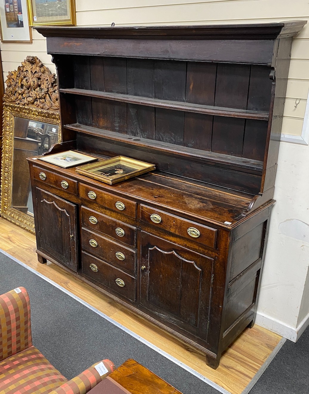 A mid 18th century oak dresser, fitted over with an open boarded rack, the latter reduced in height, length 184cm, depth 53cm, height 188cm